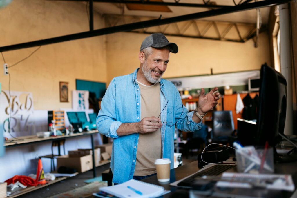 Mature small business owner having a video call in his workshop